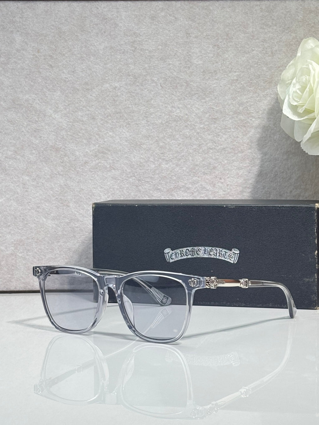 Chrome glasses with clear frames and dark lenses, chrome temple details