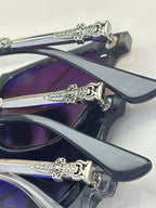 Chrome glasses close-up of dark frames and purple-blue lenses, ornate chrome hinge