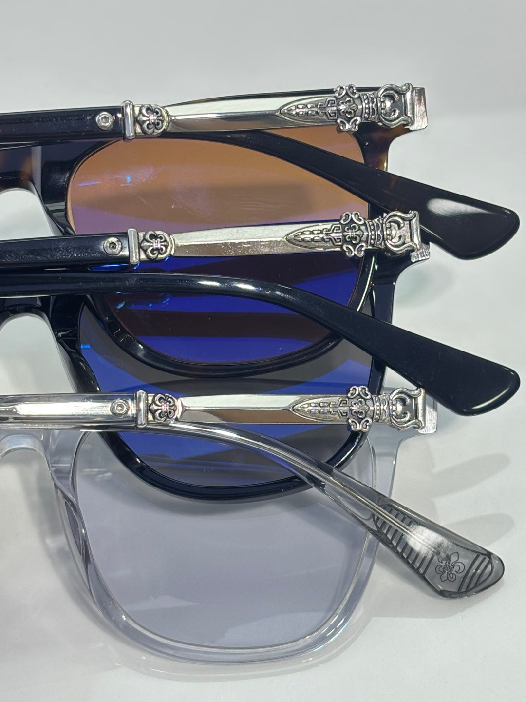Chrome glasses with navy frames and blue-tinted lenses, chrome temple engravings