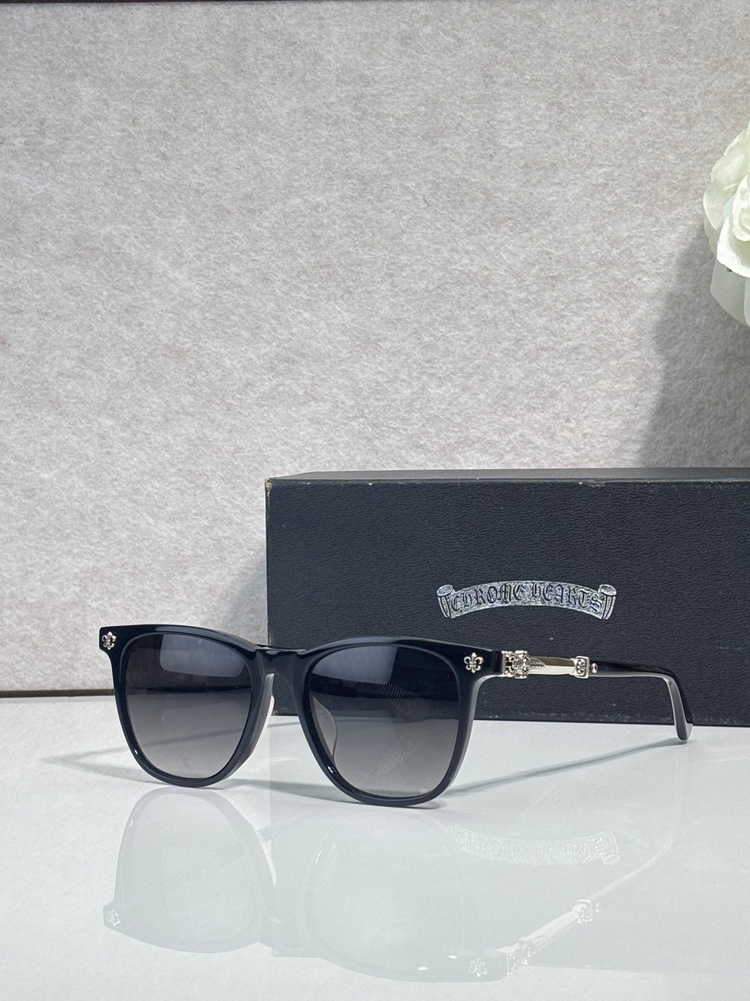 Chrome glasses with dark frames and clear-tinted lenses, visible metal bar on side