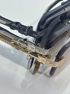 Metal sunglasses frame close-up with black temple piece and gold-tone accents