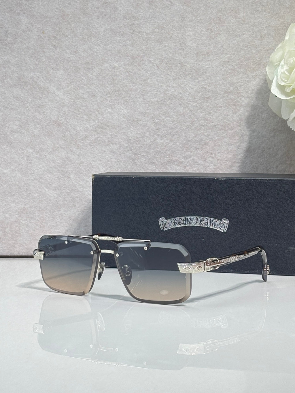 Black rectangular sunglasses with tinted lenses and gold-tone bridge detailing