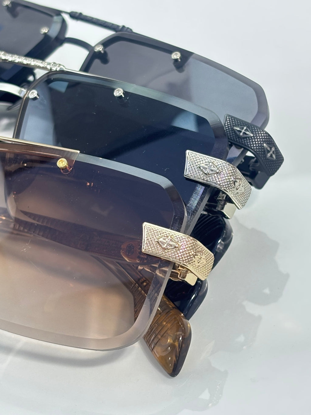 Close-up of dark sunglasses with tinted lenses and textured gold-tone temple plates