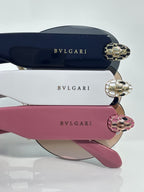Sunglasses close-up with dark blue, white, and pink temples plus gold-tone hinges