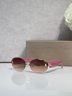 Sunglasses with reddish lenses, pink temples, and gold-tone decorative hardware