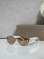 Sunglasses with brown gradient lenses, gold-tone frame, and white temples