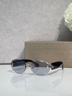 Sunglasses with dark blue lenses, black temples, and gold-tone decorative detail