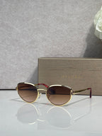 Gold-tone round sunglasses with dark gradient lenses and slim metal arms