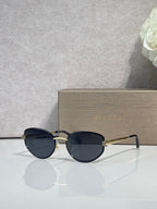 Blue-tinted oval sunglasses with gold-tone accents and thin metal temples
