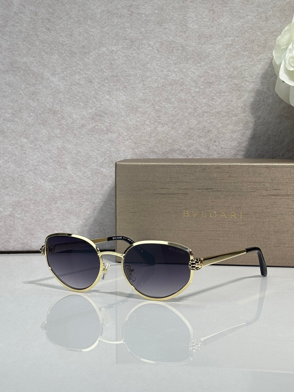 Gold-tone round sunglasses with dark navy tinted lenses and thin metal temples
