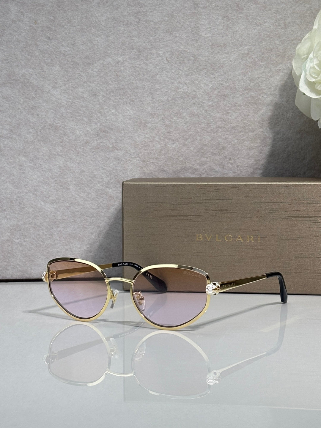 Gold-tone oval sunglasses with dark tinted lenses and metal bridge detail