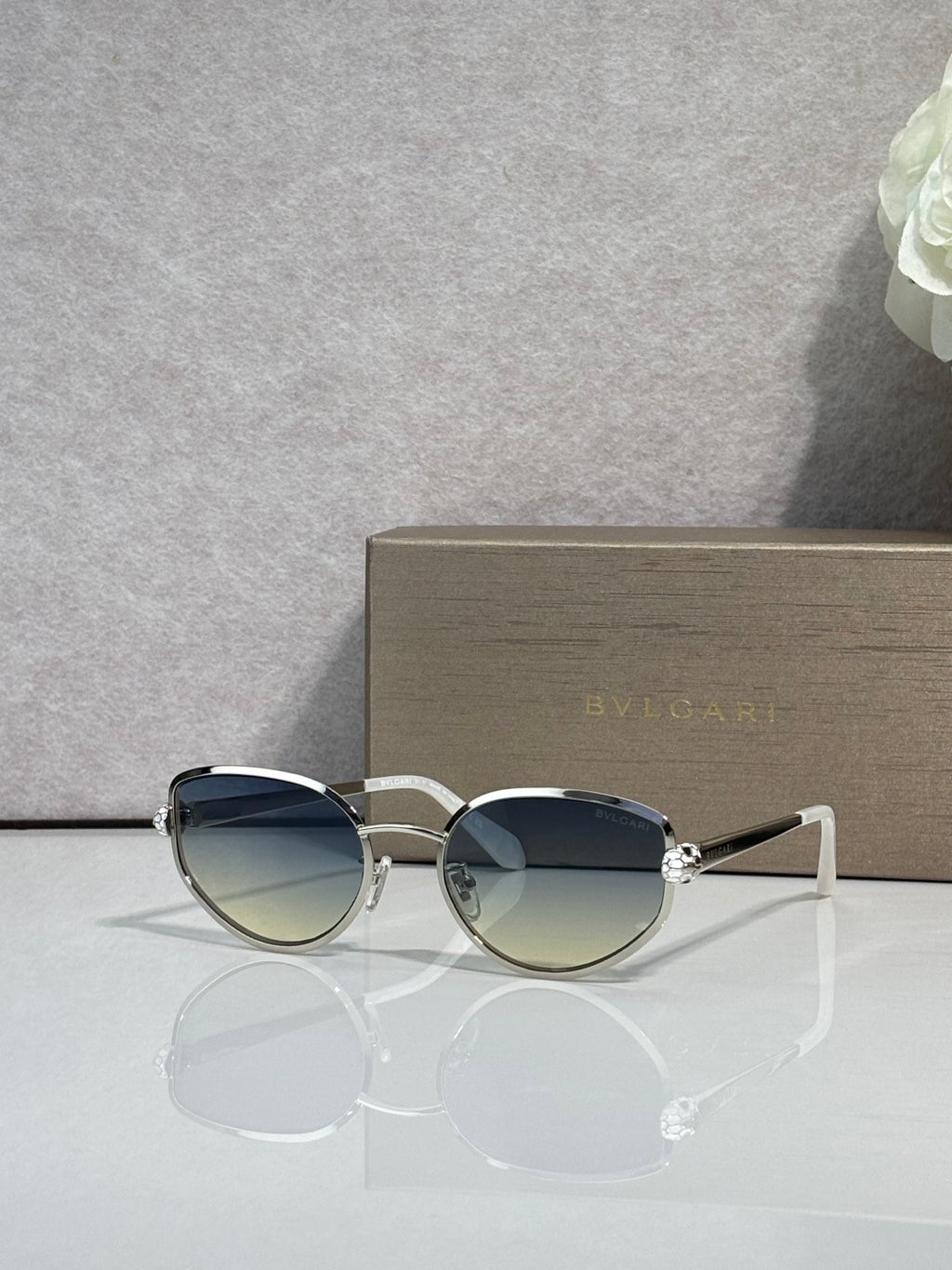 Silver-tone oval sunglasses with gradient blue lenses and metal bridge details