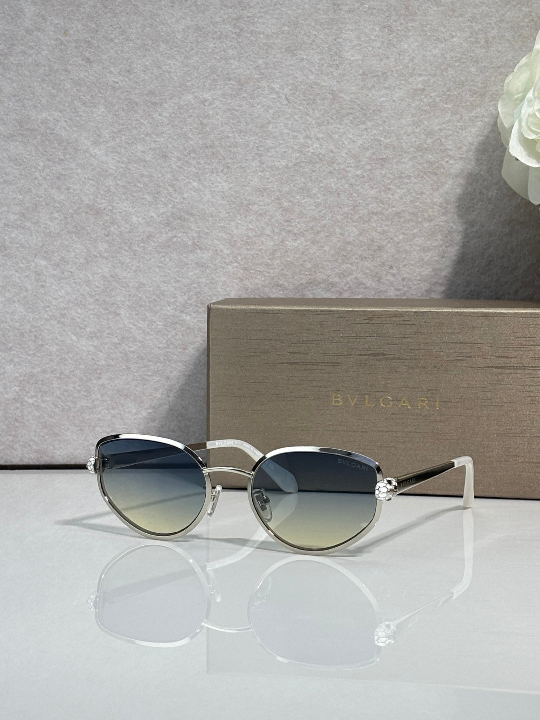 Silver-tone oval sunglasses with gradient blue lenses and metal bridge details