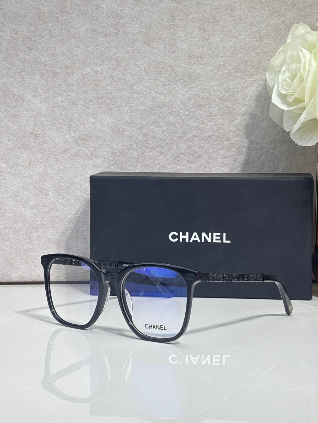 Chanel glasses with dark blue acetate frames and blue lenses, metal logo accents.