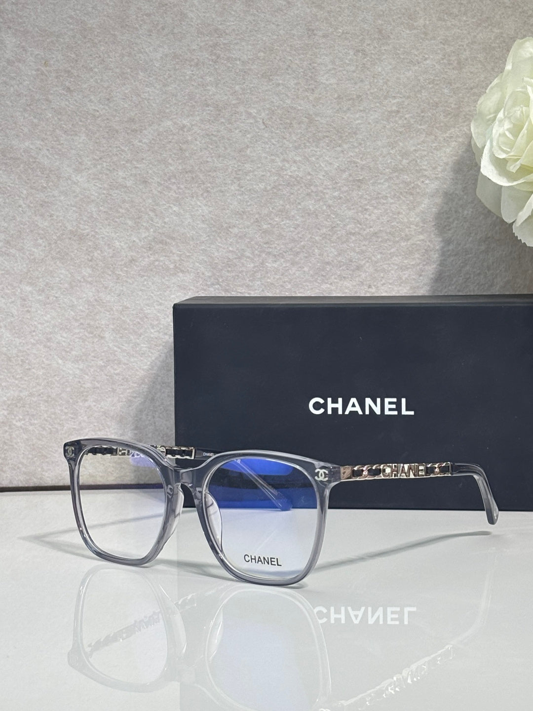 Eyeglasses with dark blue acetate frames, blue-tinted lenses, CHANEL logo on temple.