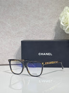 Chanel glasses with dark frames, blue-tinted lenses, and metal temple accents