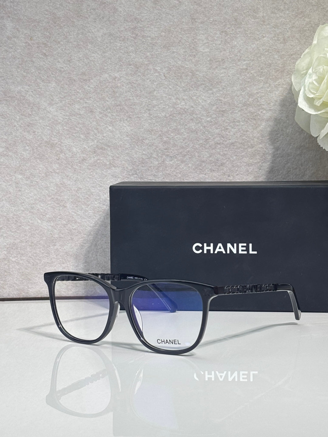 Chanel eyeglasses with dark rectangular frames and blue-tinted lenses, front view