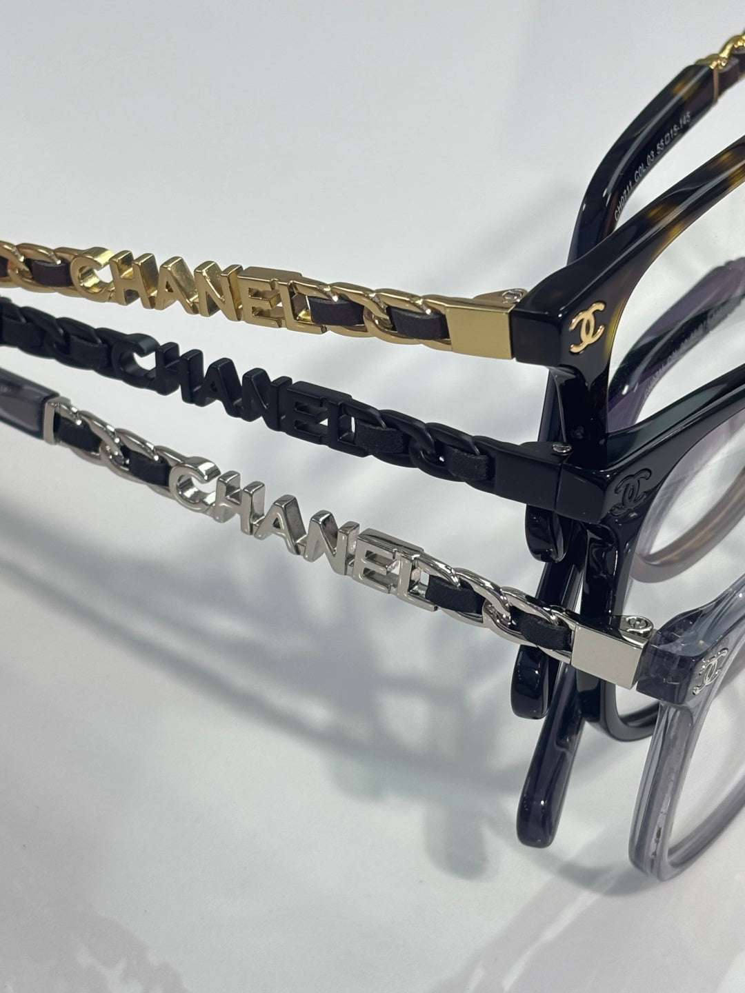 Chanel glasses temple detail with gold chain links and navy braided accent