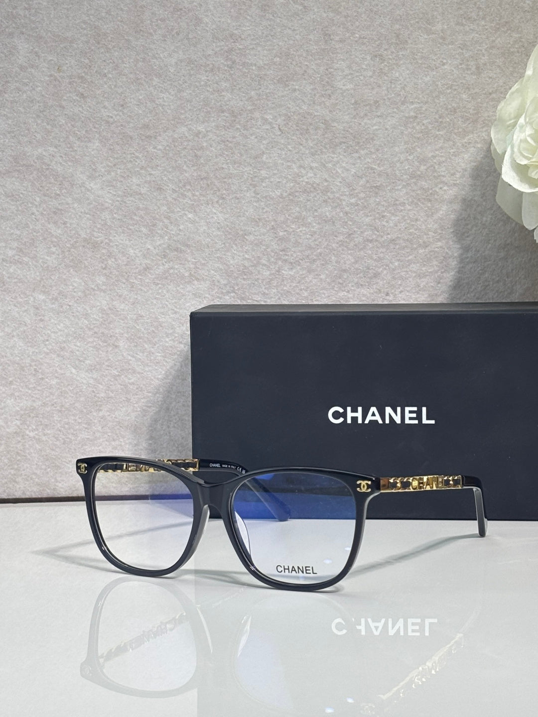 Chanel eyeglasses with dark frames and blue-tinted lenses, side profile view