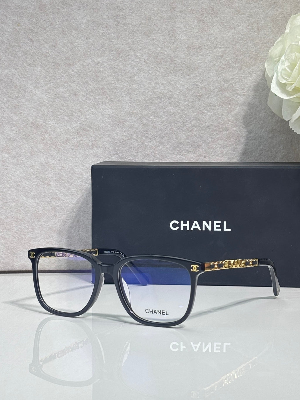 Dark blue rectangular eyeglasses with blue lenses and gold Chanel logo details