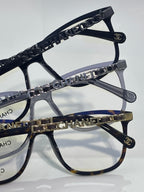 Dark rectangular eyeglasses with chain-linked temple and Chanel logo on frame edge