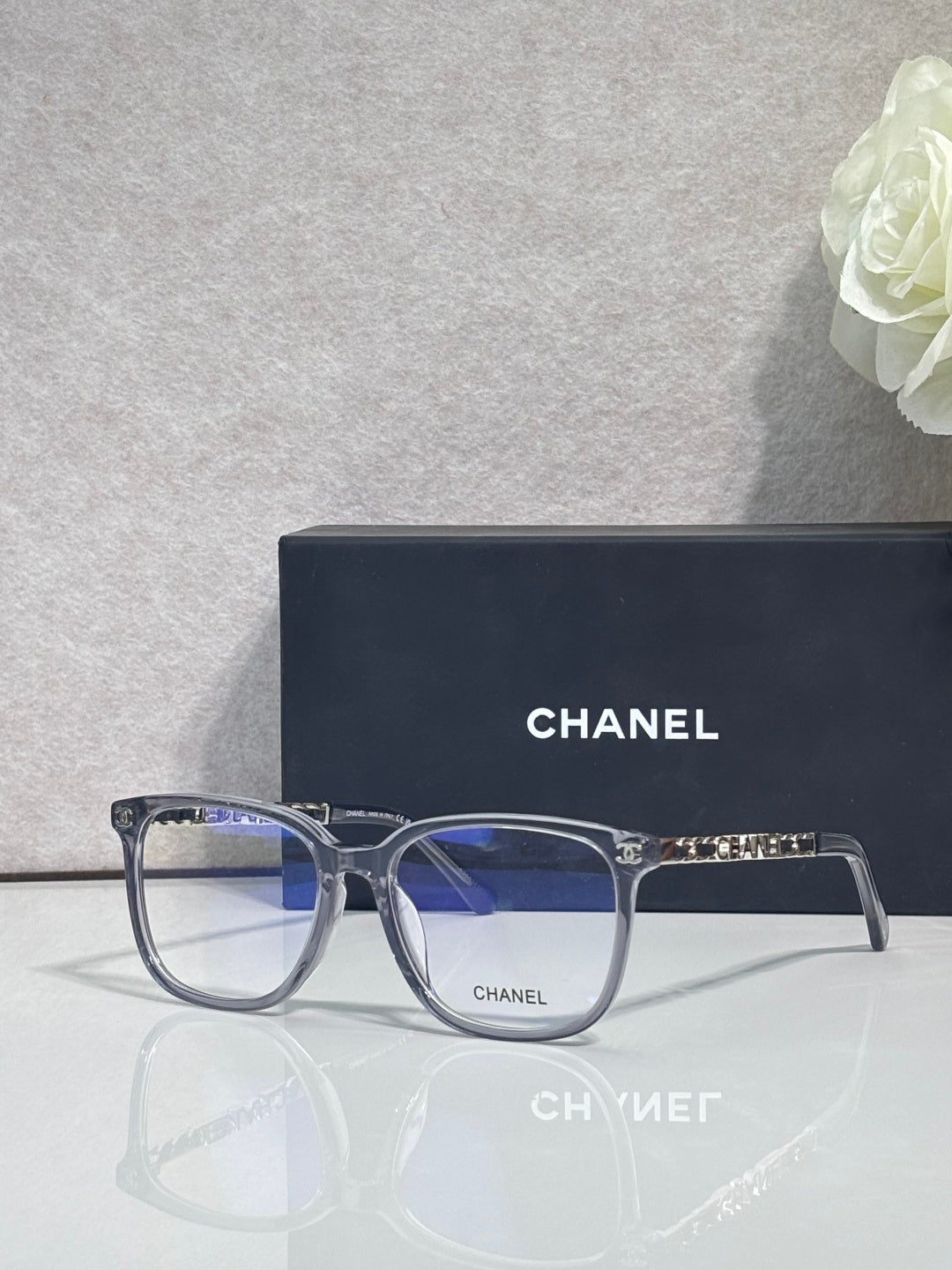 Dark blue rectangular eyeglasses with blue-tinted lenses and gold Chanel logo on bridge