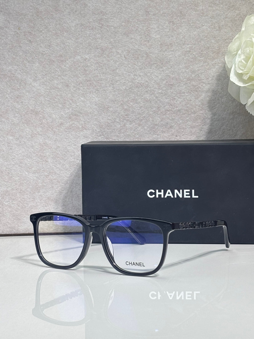 Dark blue eyeglasses with rectangular frames, blue lenses, and Chanel mark on front