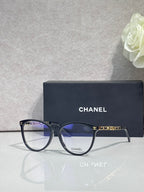 Chanel eyeglass frames, dark blue round lenses with gold CHANEL logos on arms