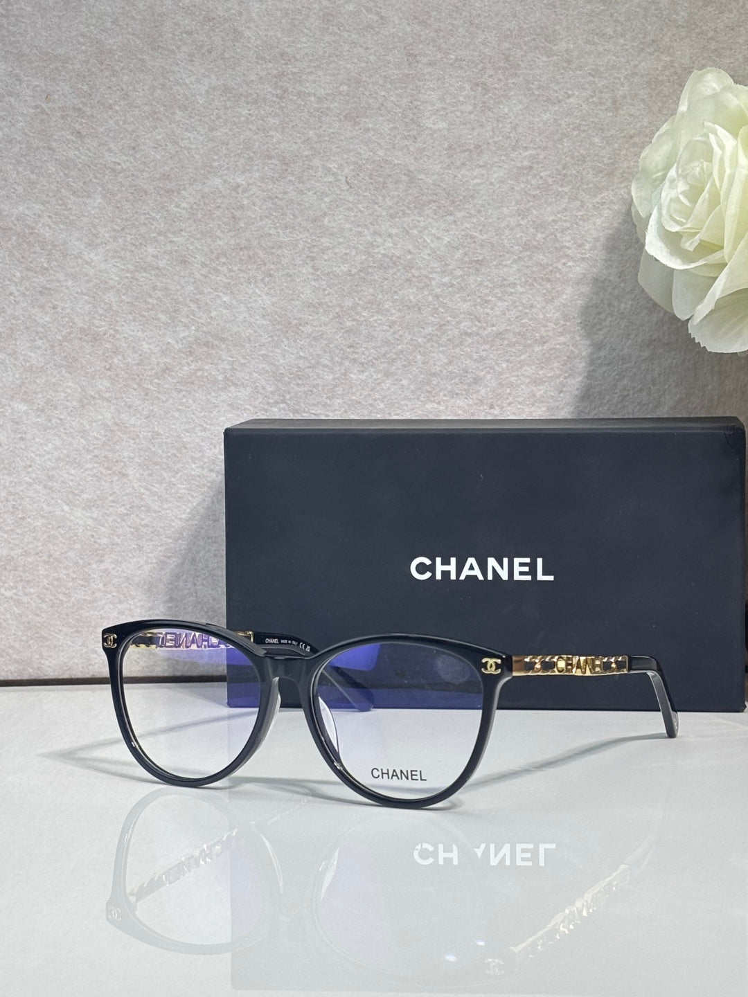 Chanel eyeglass frames, dark blue round lenses with gold CHANEL logos on arms