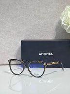 Chanel eyeglass frames, dark blue with gold CHANEL branding on temples and front