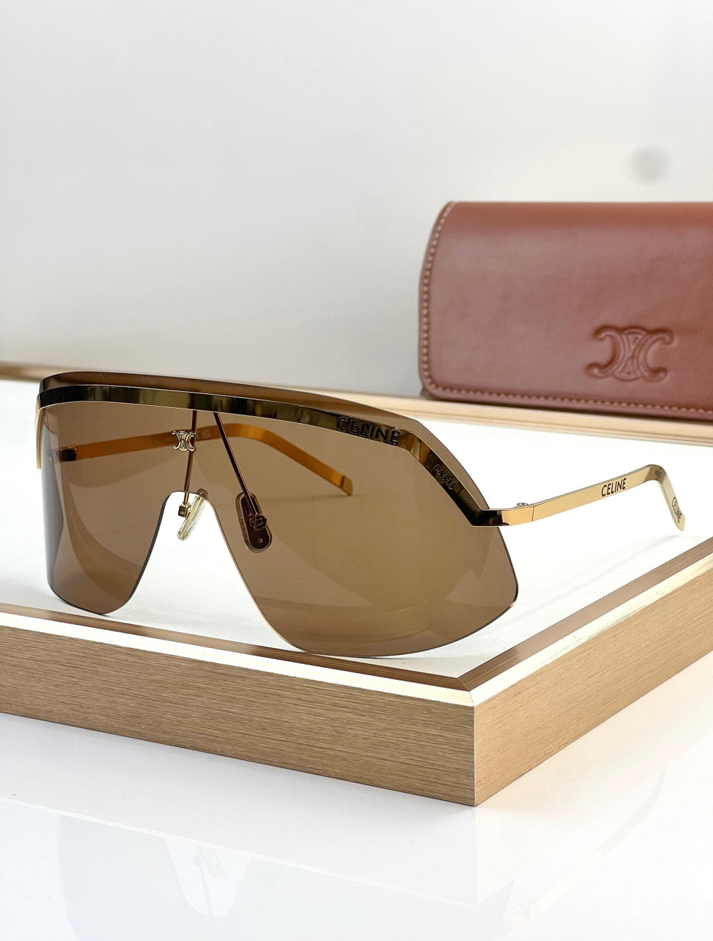 Shield sunglasses with gold trim and amber gradient lenses