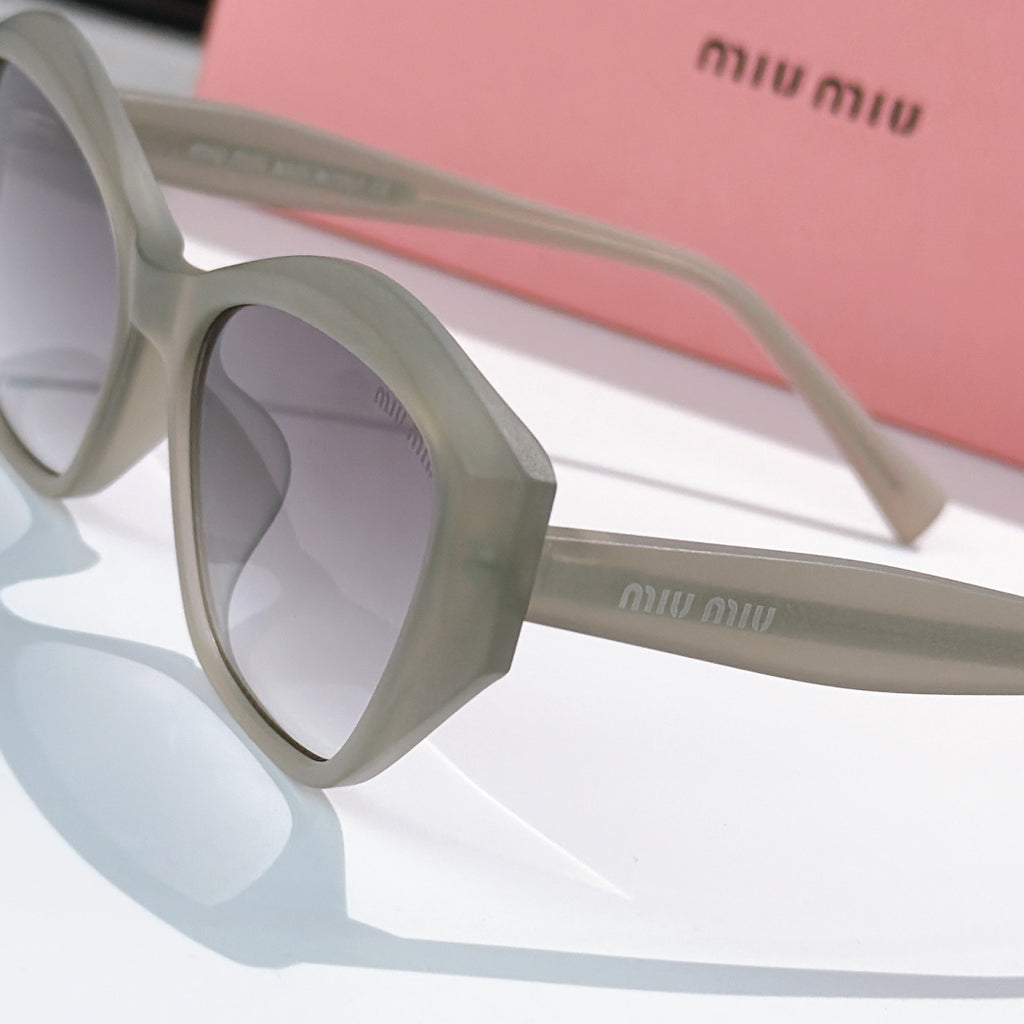 Light gray cat-eye sunglasses close-up, showing temple and lens shape