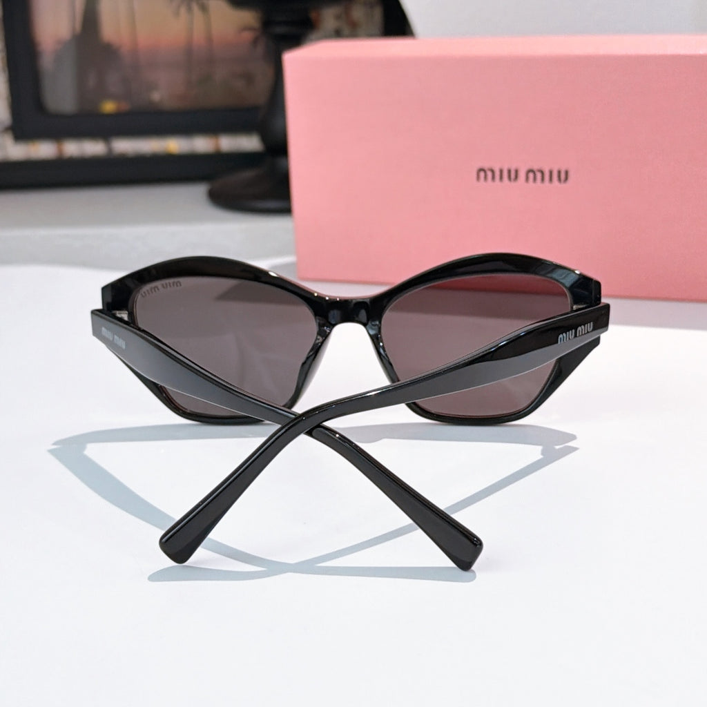Black cat-eye sunglasses with dark tinted lenses and sculpted center bridge