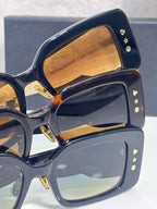 Dior sunglasses with navy frame, heart studs, and amber-tinted square lenses