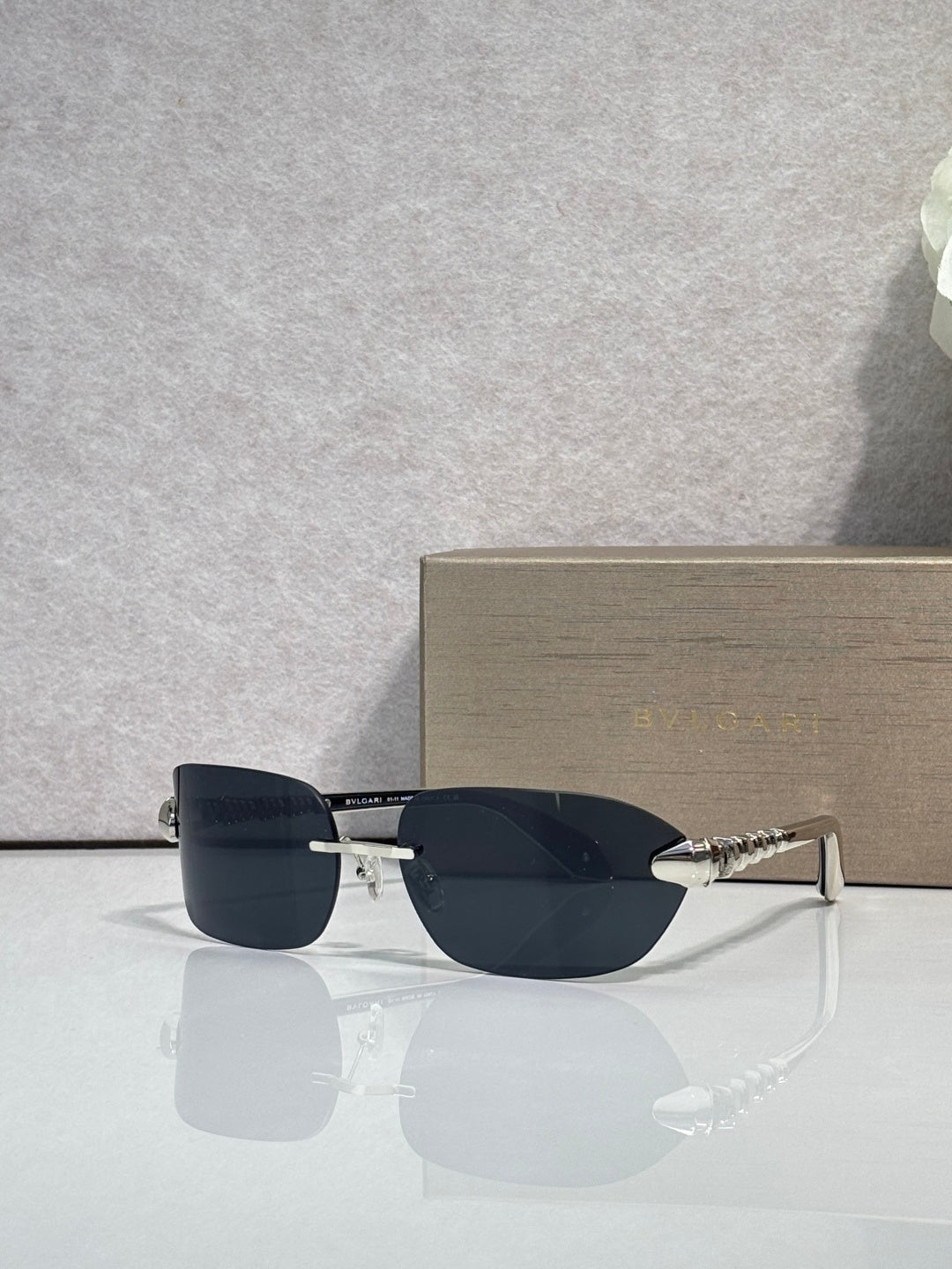 Sunglasses with dark lenses and silver-and-gold metal frame, three-quarter view.