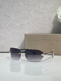 Sunglasses with dark navy lenses, silver-and-gold metal frame, side view.