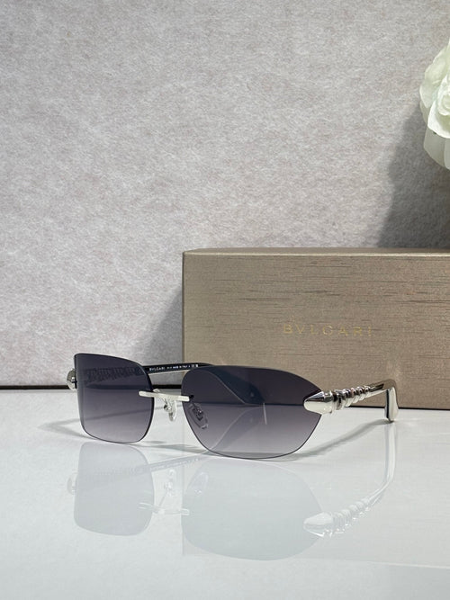 Sunglasses with dark navy lenses, silver-and-gold metal frame, side view.