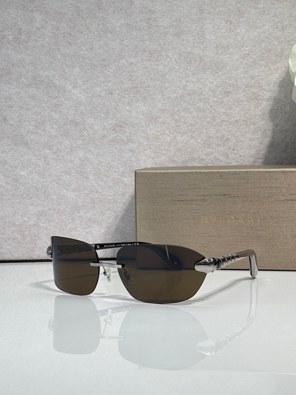 Sunglasses with dark lenses and silver-and-gold metal frame, front angle view.