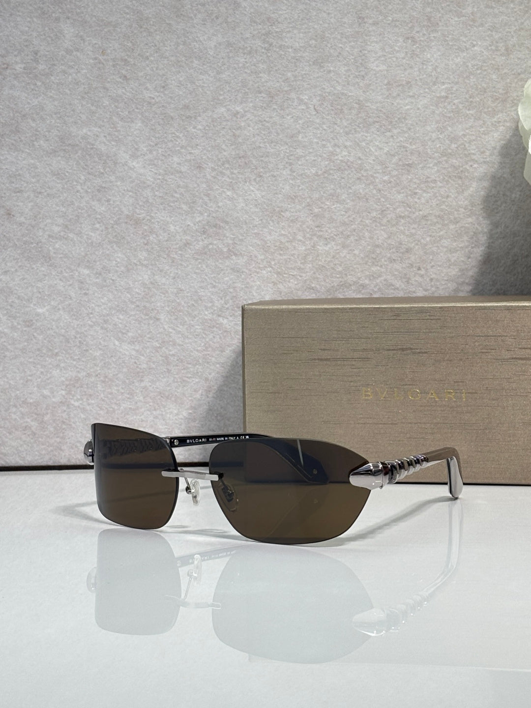 Sunglasses with dark lenses and silver-and-gold metal frame, front angle view.