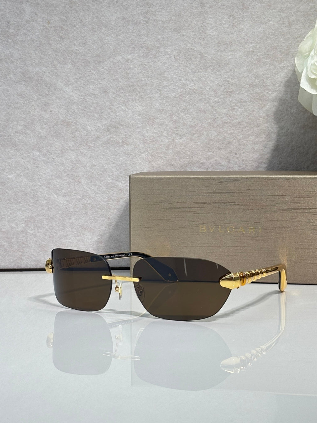 Sunglasses with dark lenses and gold metal frame, three-quarter view.