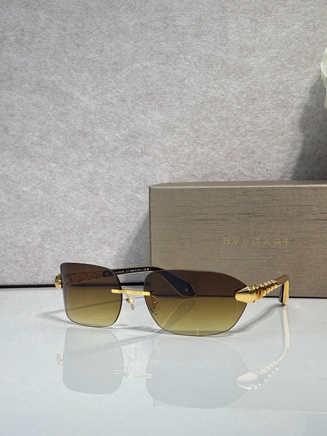 Sunglasses with brown lenses and gold metal frame, front angle on display.