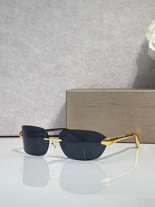 Sunglasses with dark navy lenses and gold metal frame, front angle on display.