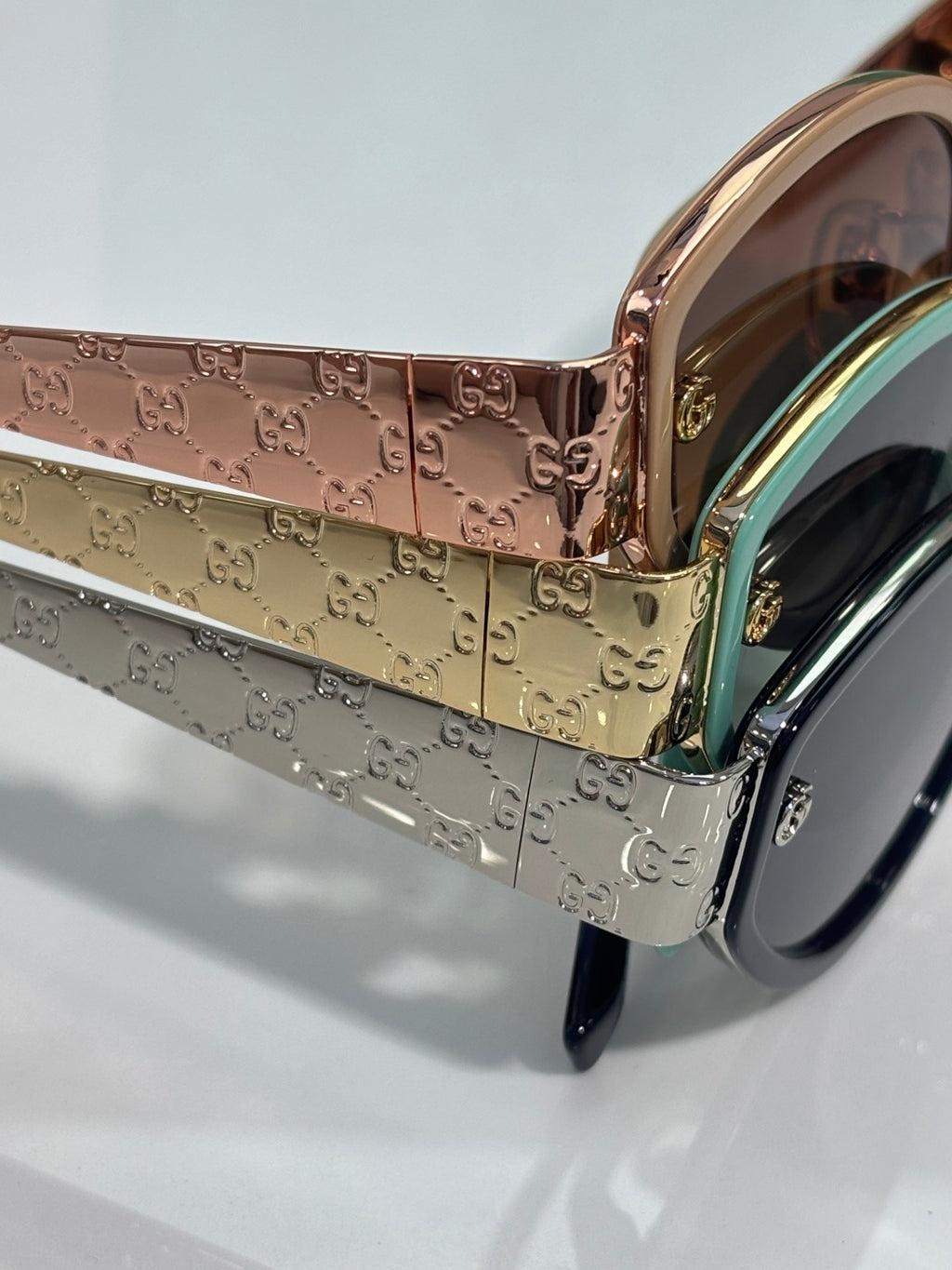 Embossed cat-eye sunglasses with rose-gold and silver panels, blue-accent temples