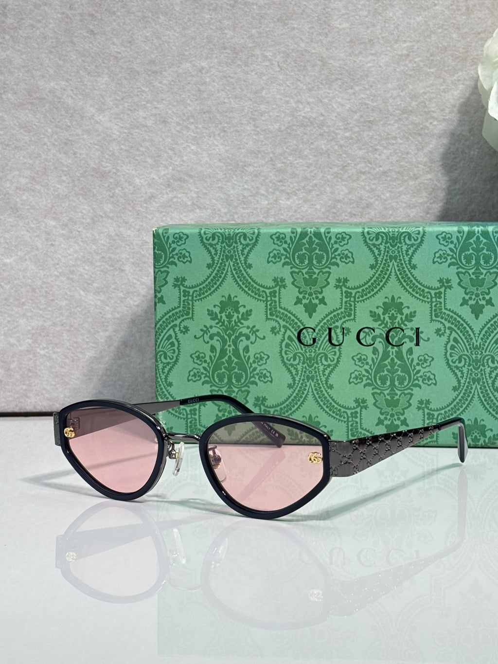 Cat-eye sunglasses with black frames and pink-tinted gradient lenses