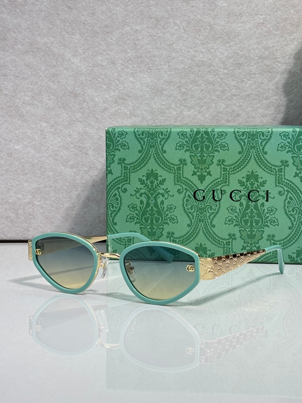 Cat-eye sunglasses with teal frames and light gradient lenses