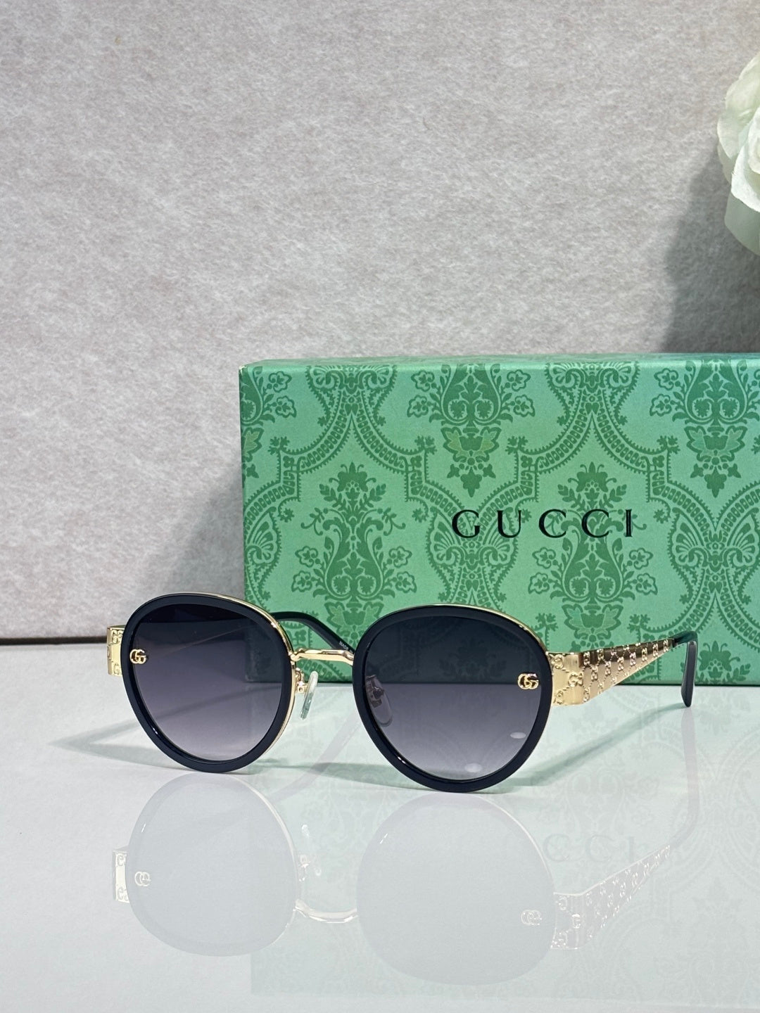 Gucci round sunglasses with navy lenses and black frames, gold logo hardware