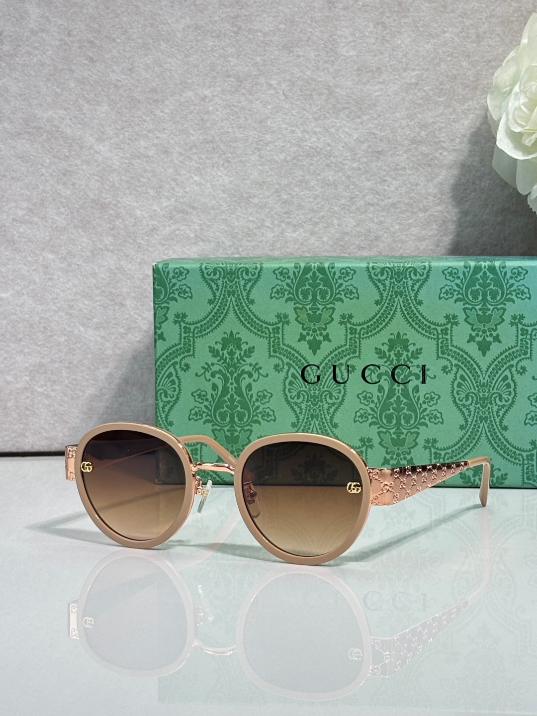 Gucci round sunglasses with tan lenses and light gold frame, decorative arms
