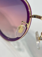 Gucci round sunglasses close-up of purple rim and gold hinge hardware