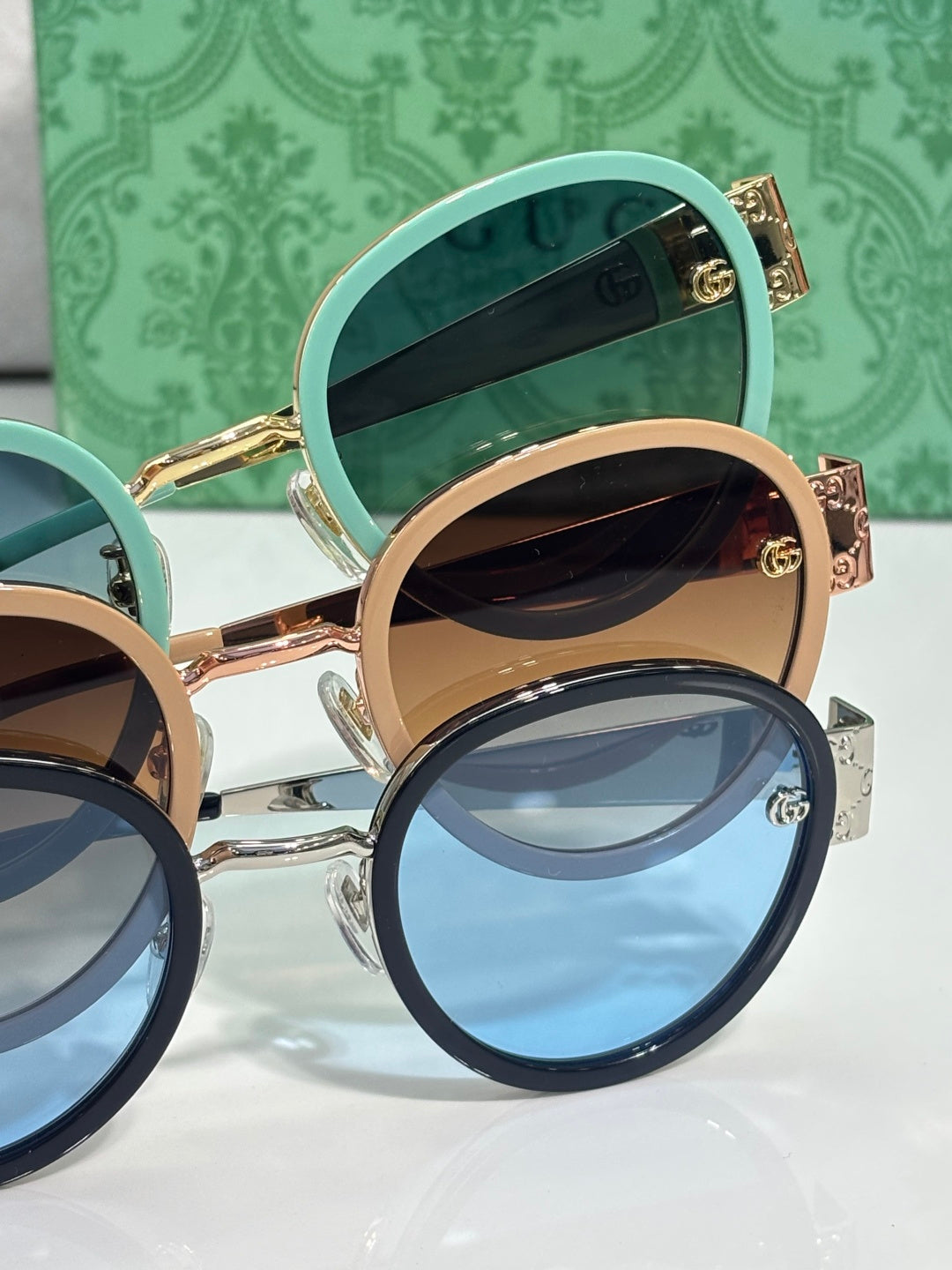 Gucci stacked round sunglasses with teal and tan lenses and gold logo arms