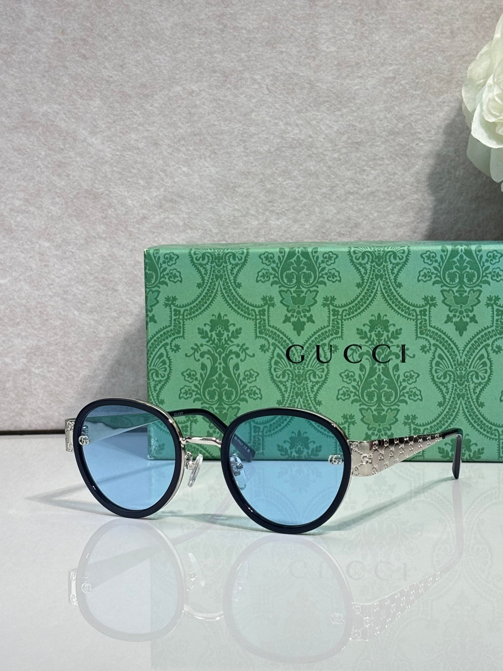Gucci round sunglasses with dark blue lenses and black frames, gold logo detail